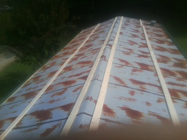 Rusted metal roof panels with new wood purlins before replacement — Storm Damage Roof Repair in Goodview by Roofing Brothers